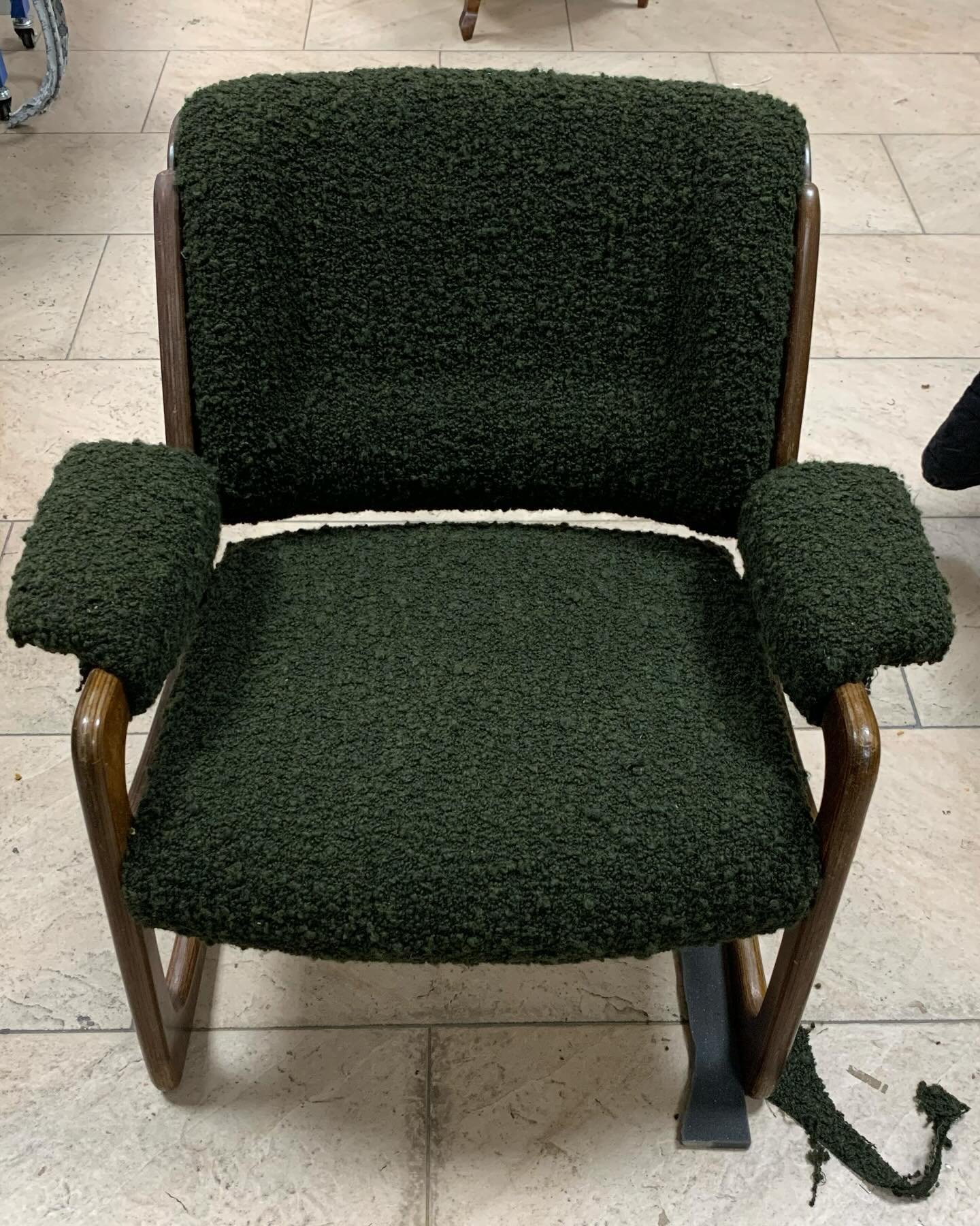 Butaca de madera tapizada en tejido bouclé verde